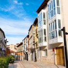 Calle de la Puebla, via pedonale del centro storico di Burgos. Le tipiche galerías vetrate accompagnano lo sguardo verso la gotica chiesa di San Lesmes, affacciata su Plaza de San Juan.