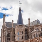 Sul retro del Palazzo Episcopale di Astorga, absidi poligonali, strette monofore e coperture in ardesia rivelano il linguaggio neogotico con cui Gaudí reinterpretò il Medioevo.