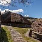 Le pallozas di O Cebreiro seguono forme ovali, con muri bassi in pietra e grandi coperture di paglia di segale: tecniche ancestrali perfettamente integrate nel paesaggio galiziano.