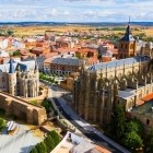 Dall’alto, la Cattedrale di Santa María domina Astorga tra guglie gotiche e torri barocche; accanto, il Palazzo Episcopale di Gaudí sorprende con il suo profilo neogotico.