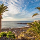 La Playa de La Arena, a Puerto de Santiago, si apre tra palme e rocce vulcaniche, con la sua sabbia nera lambita dall’Atlantico e illuminata dalla calda luce del sole.