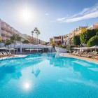 L’ampia piscina del Servatur Isora Suites 4 stelle, a Puerto de Santiago, invita al relax tra lettini, palme e giardini, sotto il luminoso cielo di Tenerife.