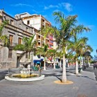 Nel cuore di Plaza de la Candelaria, palme e caffè accompagnano la storica Fuente de La Pila, prima fontana pubblica di Santa Cruz, lungo il vivace percorso pedonale verso Calle del Castillo