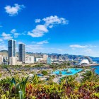 Tra palme e vegetazione tropicale si apre la moderna Santa Cruz de Tenerife, con il Parque Marítimo César Manrique, le torri cittadine e l’iconico Auditorio de Tenerife affacciati sull’Atlantico.