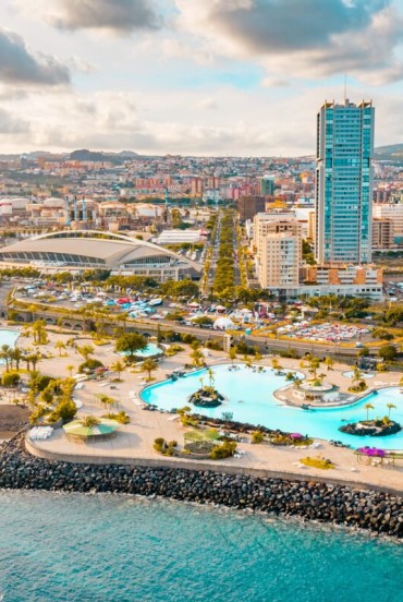Il Parque Marítimo César Manrique si affaccia sull’oceano con piscine di acqua salata, palme e terrazze solarium, mentre le Torres de Santa Cruz disegnano il moderno skyline della capitale di Tenerife.