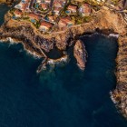 Vista dall’alto, la Piscina Naturale di Isla Cangrejo si apre tra le rocce vulcaniche di Santiago del Teide, protetta da un muro e circondata dal blu profondo dell’Atlantico.
