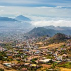 La città di San Cristóbal de La Laguna si estende nella valle tra quartieri, case colorate e aree coltivate, mentre le montagne di Tenerife ne disegnano l’ampio orizzonte.