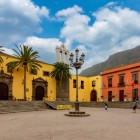 Nel cuore di Garachico, Plaza de la Libertad riunisce l’ex convento di San Francisco e il Municipio, tra portali in pietra vulcanica, facciate vivaci e palme canarie.