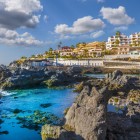 La costa di Puerto de Santiago alterna rocce vulcaniche, piscine naturali e acque turchesi, mentre le case affacciate sull’Atlantico disegnano un luminoso paesaggio canario.