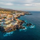Vista dall’alto, la costa di Puerto de Santiago segue le scure colate laviche, dove l’Atlantico si frange in spuma turchese e l’abitato accompagna il profilo selvaggio dell’isola.
