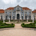 Il raffinato Palazzo Nazionale di Queluz si apre sui suoi giardini geometrici, tra siepi scolpite, fontane e decorazioni rococò che evocano lo splendore della corte portoghese.