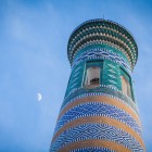 Osservato dal basso, il Minareto Islam Khodja rivela la ricchezza delle sue maioliche turchesi e blu, disposte in fasce decorative che accompagnano lo sguardo fino alla sommità.