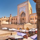 Nel cuore di Itchan Kala, la Madrasa Allakuli Khan domina le bancarelle del Bazar, dove artigianato e architetture ottocentesche raccontano l’anima mercantile di Khiva.