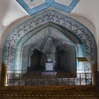 All’interno del Mausoleo di Pakhlavan Mahmud, la tomba venerata è incorniciata da un raffinato arco rivestito di maioliche blu e turchesi, cuore spirituale di Khiva.