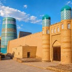 La Kuhna Ark, antica cittadella dei khan di Khiva, si apre tra possenti mura e torri merlate: mattoni, portali e cupole turchesi raccontano il potere di Itchan Kala.