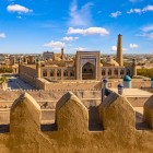 Dalle mura merlate di Kuhna Ark, lo sguardo attraversa Itchan Kala tra madrase, cupole e minareti, rivelando il fascino senza tempo dell’antica Khiva.