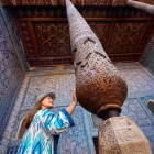 Nel Palazzo Tash-Khauli di Khiva, osserva la straordinaria colonna lignea scolpita: motivi geometrici e vegetali dialogano con le maioliche blu, espressione dell’arte khanide.