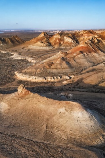 Nel deserto del Kyzylkum, tra Khiva e Bukhara, rilievi scolpiti dal vento e sfumature ocra raccontano il volto autentico dell’antica Via della Seta