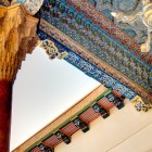 Nel complesso di Bahauddin Naqshband, l’ayvan della Moschea Khakim Kushbegi incanta con colonne, muqarnas e soffitti dipinti nell’arte tradizionale di Bukhara.