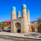 La Madrasa Chor Minor accoglie il visitatore con quattro torri coronate da cupole turchesi, simbolo della Bukhara ottocentesca e delle sue antiche scuole coraniche.