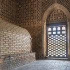 All’interno del Mausoleo di Ismail Samani, archi e intrecci di mattoni avvolgono la camera funeraria, rivelando l’armonia dell’architettura samanide del X secolo.