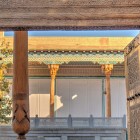 Il portale ligneo di Bahauddin Naqshband, scolpito con motivi islamici, introduce alla corte sacra tra colonne decorate, spiritualità sufi e secoli di pellegrinaggi.