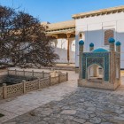 La Saho-khona custodiva l’acqua sacra dei pellegrini: quattro archi e torrette dalle cupole turchesi celebrano la vita e la spiritualità nel cuore del santuario.