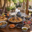 In un ristorante familiare di Nurata, il viaggiatore scopre l’ospitalità uzbeka gustando plov, shurpa, samsa, pane non, achichuk, frutta secca e tè verde.