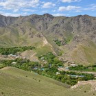 Dall’alto, Ukhum appare come una piccola oasi: case e alberi seguono l’acqua ai piedi dei Nuratau, creando un intenso contrasto con i pendii aridi e rocciosi.