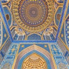 All'interno della Tilla-Kori, lo sguardo sale verso la straordinaria decorazione della moschea: blu intenso, motivi floreali e abbondanti dorature creano uno degli ambienti più spettacolari del Registan.