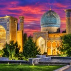Una veduta d'insieme permette di apprezzare la cupola turchese, i portali decorati e le torri del Gur-e Amir, elementi che rendono inconfondibile l'architettura timuride di Samarcanda.