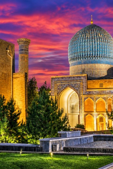 Una veduta d'insieme permette di apprezzare la cupola turchese, i portali decorati e le torri del Gur-e Amir, elementi che rendono inconfondibile l'architettura timuride di Samarcanda.