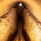 All’interno appare la sezione sotterranea del grande arco astronomico: due binari paralleli seguono la curvatura dello strumento utilizzato dagli astronomi di Ulugh Beg.