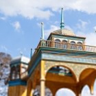 Avvicinandosi al padiglione, si osservano meglio gli archi intagliati, le tonalità azzurre e dorate e le guglie che definiscono l’originale profilo della costruzione storica.