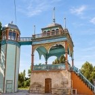 La passeggiata conduce quindi al padiglione panoramico, collegato a una torre laterale e arricchito da archi lignei, balaustre dipinte e sottili elementi decorativi del complesso.